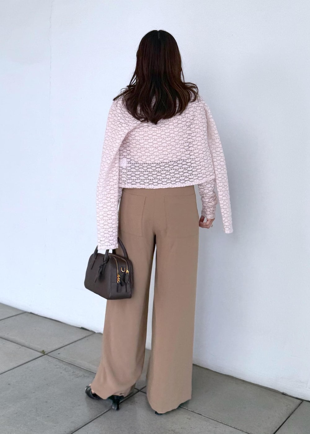 ブラウン系のハンドバッグ、ブラウン系のその他パンツ、ピンク系のカーディガン/ボレロを着用したレディースの夏コーディネートの4枚目の写真