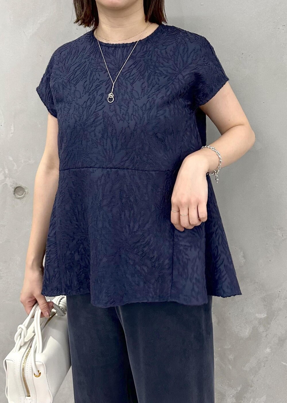 ブルー系のその他パンツ、シルバー系のサンダル、ホワイト系のショルダーバッグを着用したレディースの春コーディネートの5枚目の写真