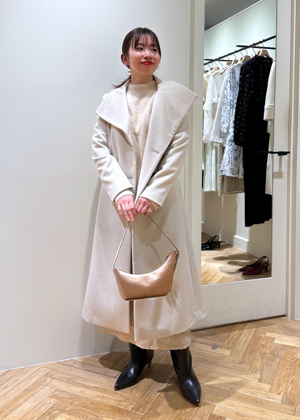 ブラック系のブーツ、ベージュ系のスカート、ベージュ系のニット/セーターを着用したレディースの冬コーディネートの5枚目の写真