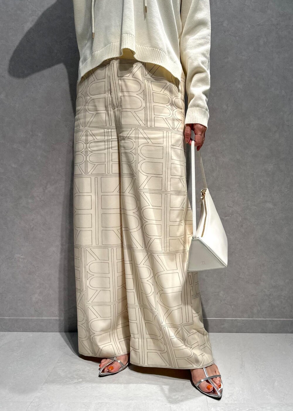 ホワイト系のニット/セーター、ホワイト系のその他パンツ、ホワイト系のハンドバッグを着用したレディースの春コーディネートの7枚目の写真