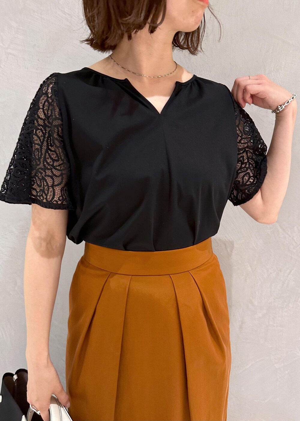 ブラック系のハンドバッグ、ブラック系のサンダル、ブラック系のTシャツ/カットソーを着用したレディースの夏コーディネートの4枚目の写真