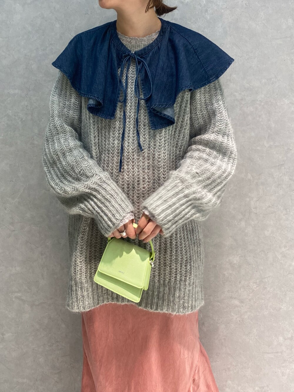 グレー系のニット/セーター、ブルー系のシャツ/ブラウス、グリーン系のバッグを着用したレディースの冬コーディネートの4枚目の写真