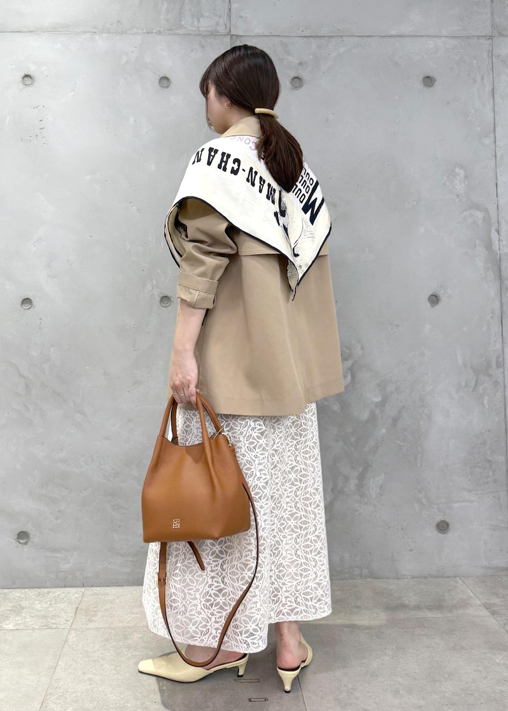 ホワイト系のTシャツ/カットソー、ベージュ系のトレンチコート、イエロー系のハンドバッグを着用したレディースの春コーディネートの3枚目の写真