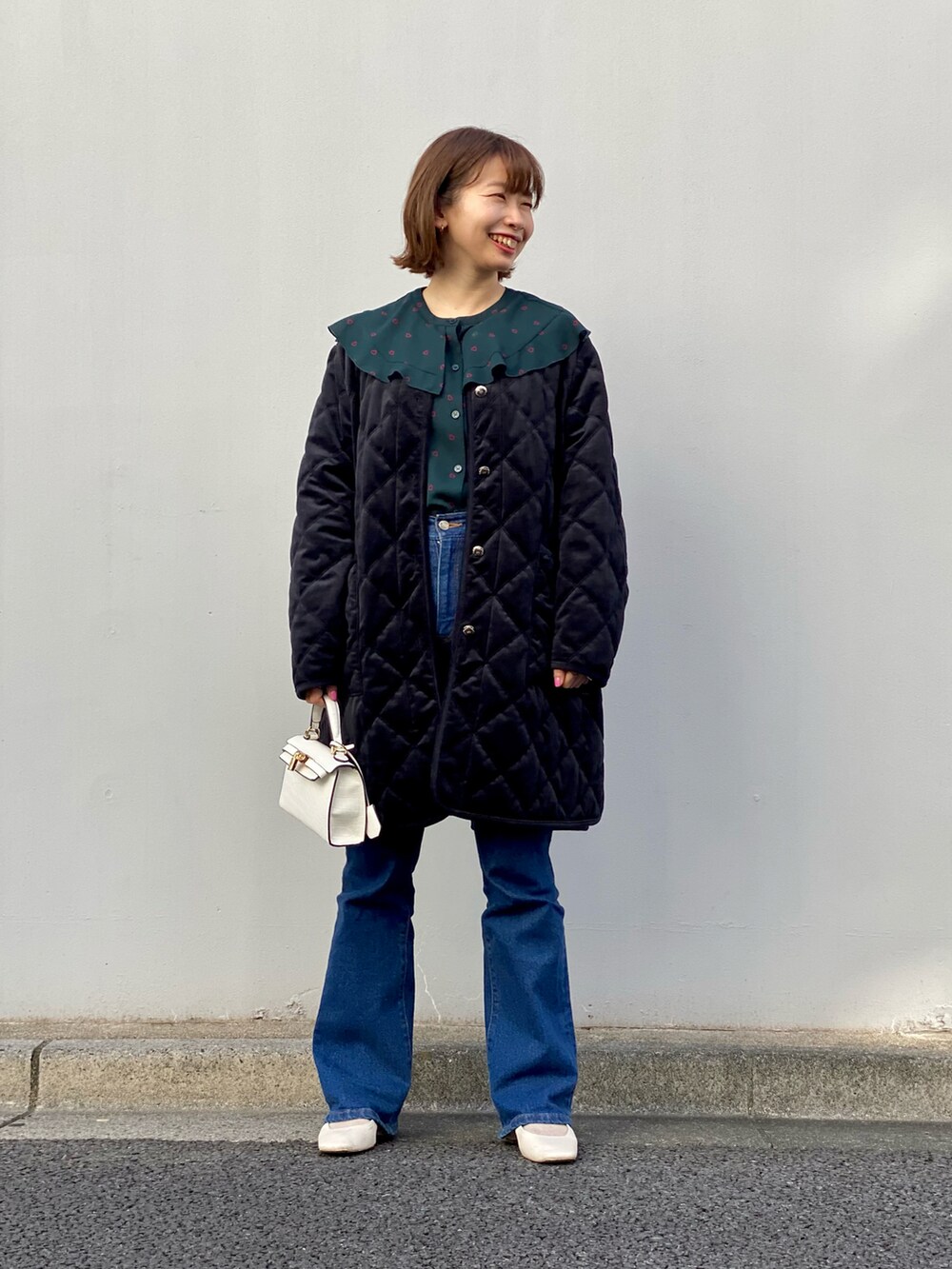 グリーン系のシャツ/ブラウス、ブラック系のブルゾン、ブルー系のデニムパンツを着用したレディースの冬コーディネートの2枚目の写真