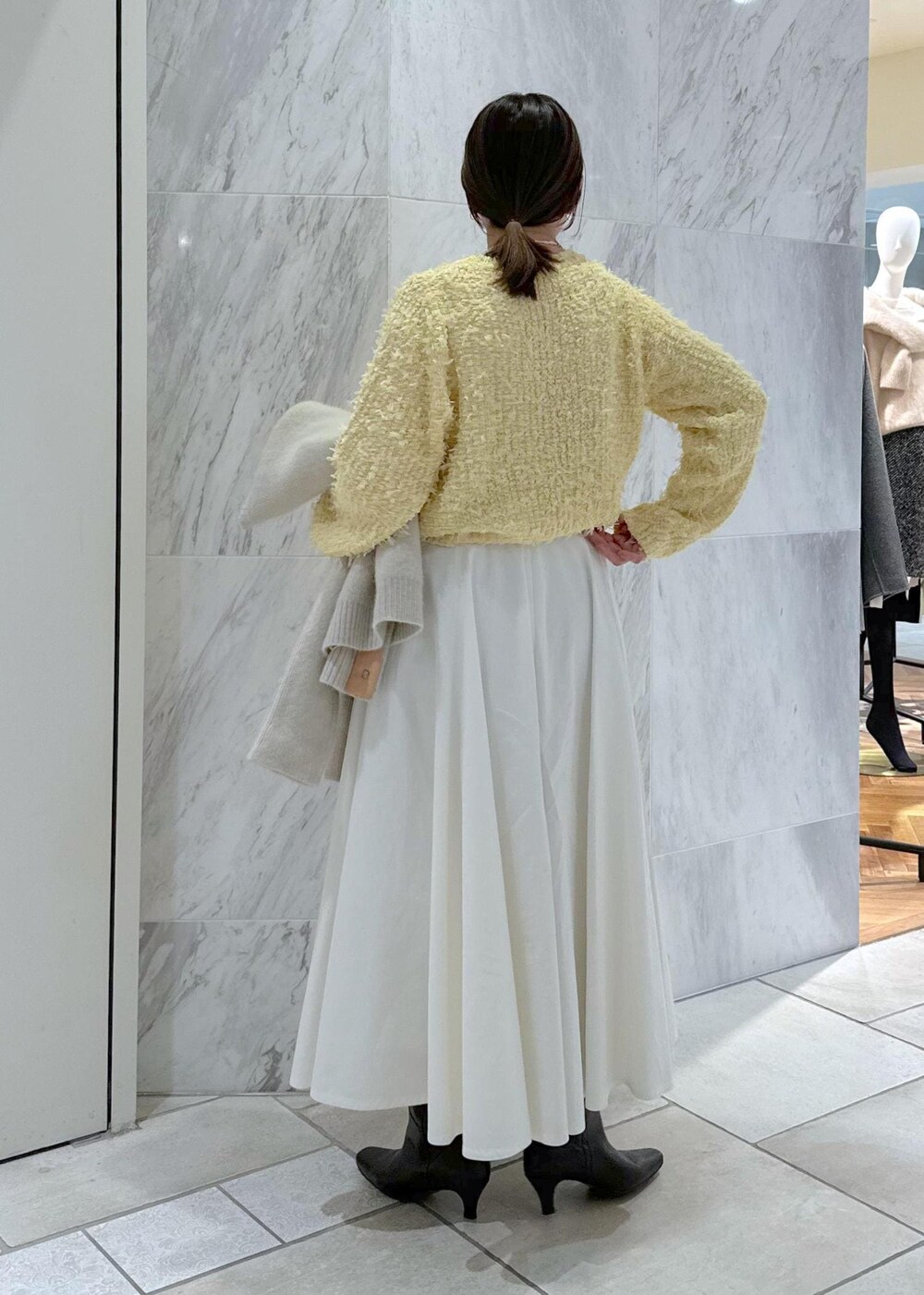 ベージュ系のショルダーバッグ、ホワイト系のカーディガン/ボレロ、ホワイト系のスカートを着用したレディースの冬コーディネートの7枚目の写真