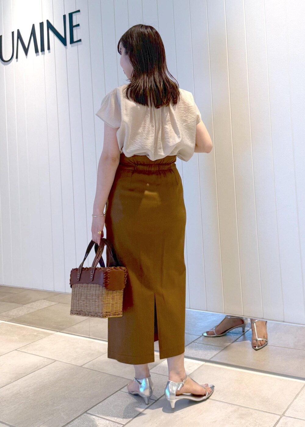 ブラウン系のスカート、ベージュ系のシャツ/ブラウスを着用したレディースの春コーディネートの4枚目の写真