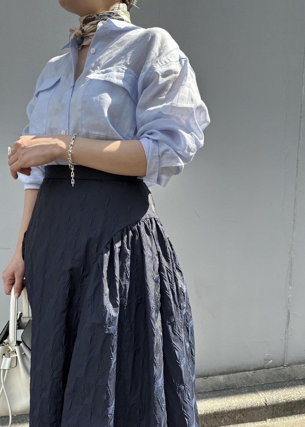 ブルー系のスカート、ブルー系のシャツ/ブラウス、ホワイト系のハンドバッグを着用したレディースの春コーディネートの8枚目の写真