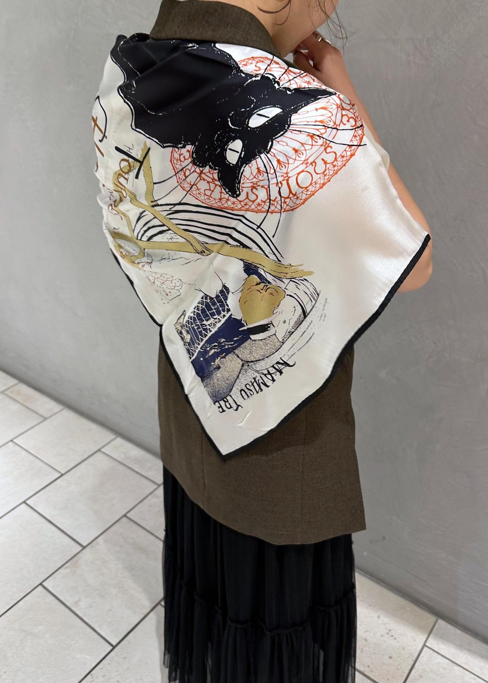 ブラック系のスカート、ゴールド系のブローチ/コサージュ、ブラック系のバンダナ/スカーフを着用したレディースの夏コーディネートの5枚目の写真