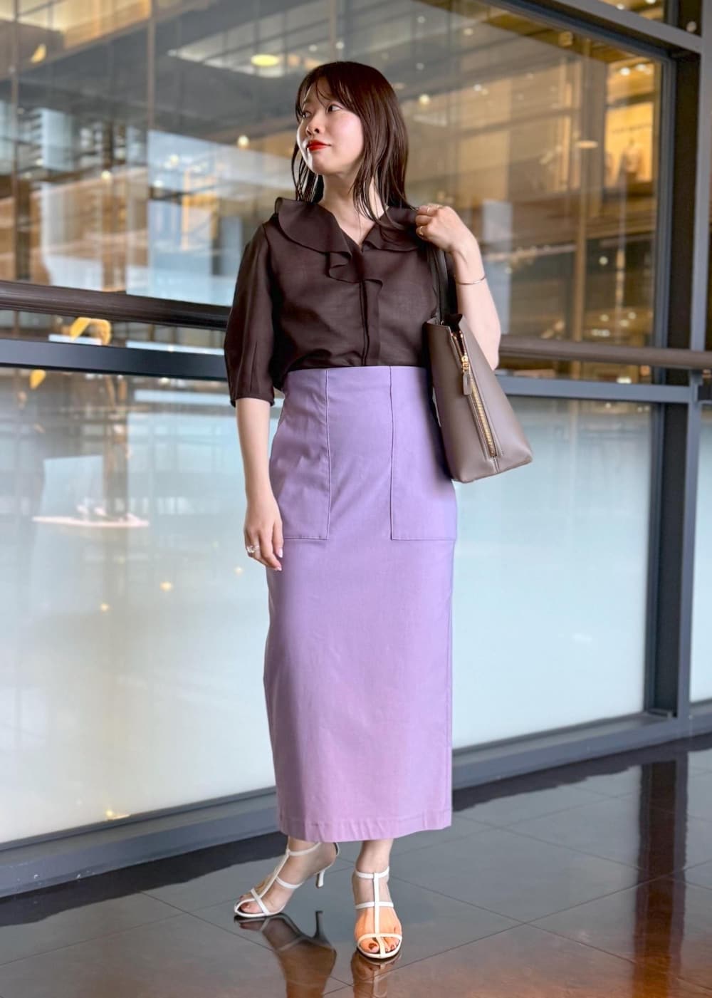 ブラウン系のトートバッグ、パープル系のスカート、ブラウン系のシャツ/ブラウスを着用したレディースの春コーディネートの9枚目の写真