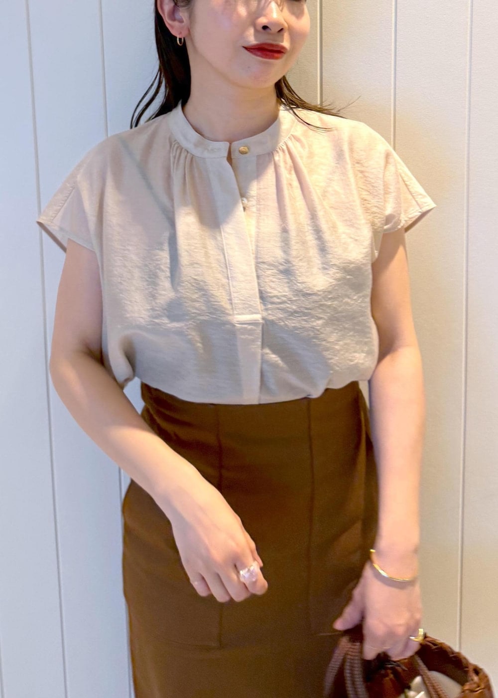 ブラウン系のスカート、ベージュ系のシャツ/ブラウスを着用したレディースの春コーディネートの5枚目の写真
