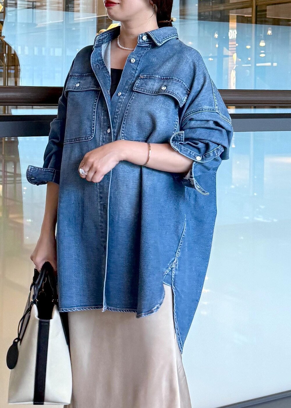 ベージュ系のスカート、ブルー系のシャツ/ブラウス、ホワイト系のトートバッグを着用したレディースの夏コーディネートの5枚目の写真