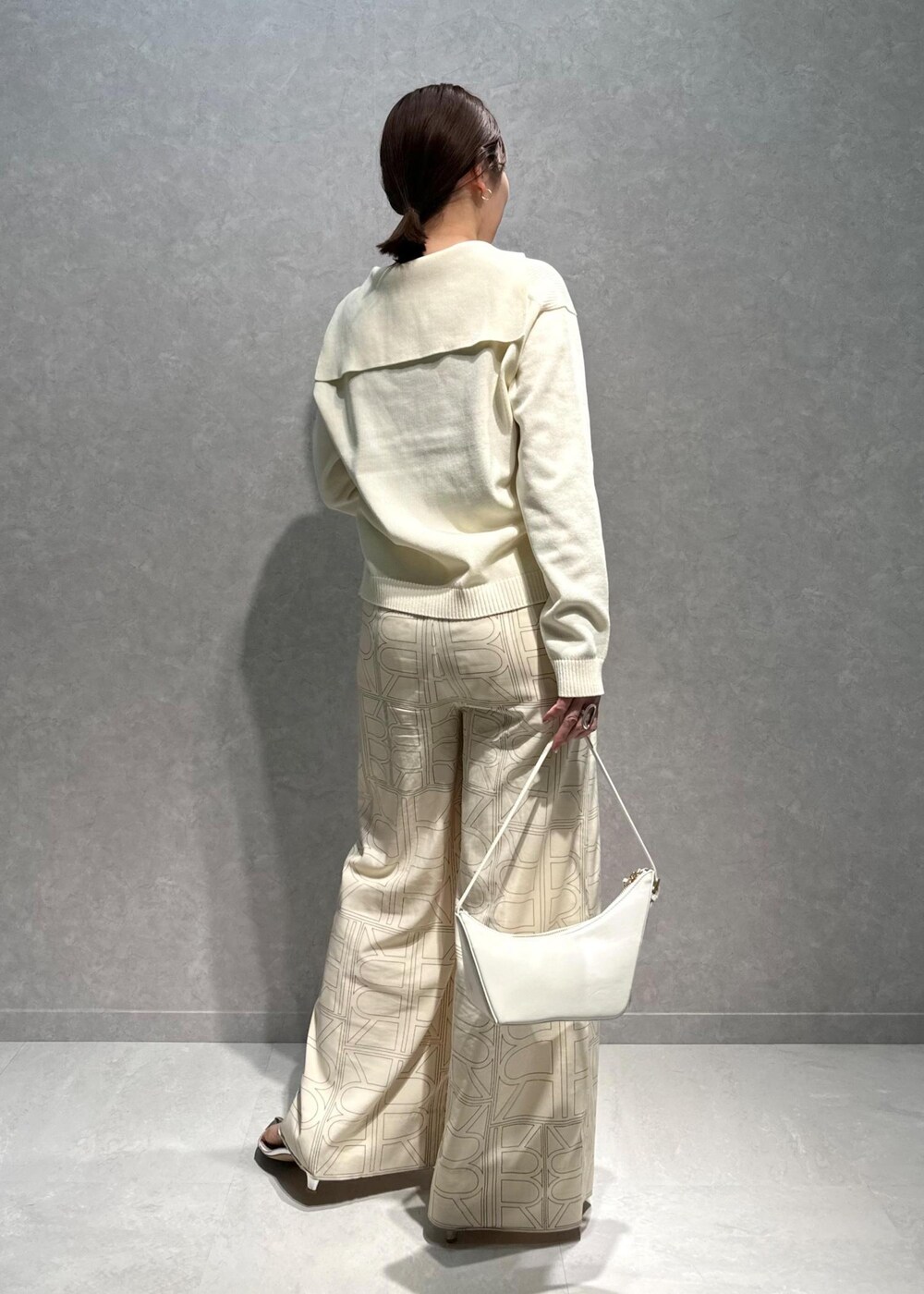 ホワイト系のニット/セーター、ホワイト系のその他パンツ、ホワイト系のハンドバッグを着用したレディースの春コーディネートの4枚目の写真