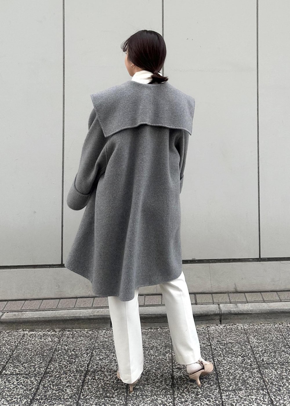 グレー系のその他アウター、ベージュ系のパンプス、ホワイト系のハンドバッグを着用したレディースの冬コーディネートの6枚目の写真