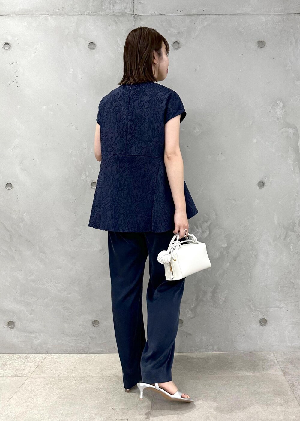 ブルー系のその他パンツ、シルバー系のサンダル、ホワイト系のショルダーバッグを着用したレディースの春コーディネートの2枚目の写真