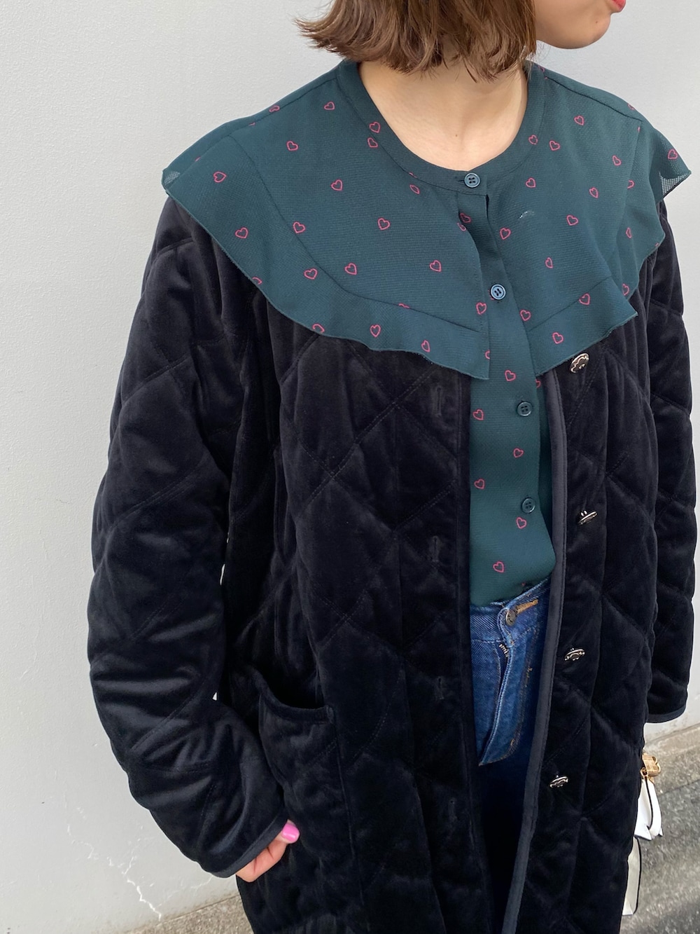 グリーン系のシャツ/ブラウス、ブラック系のブルゾン、ブルー系のデニムパンツを着用したレディースの冬コーディネートの4枚目の写真