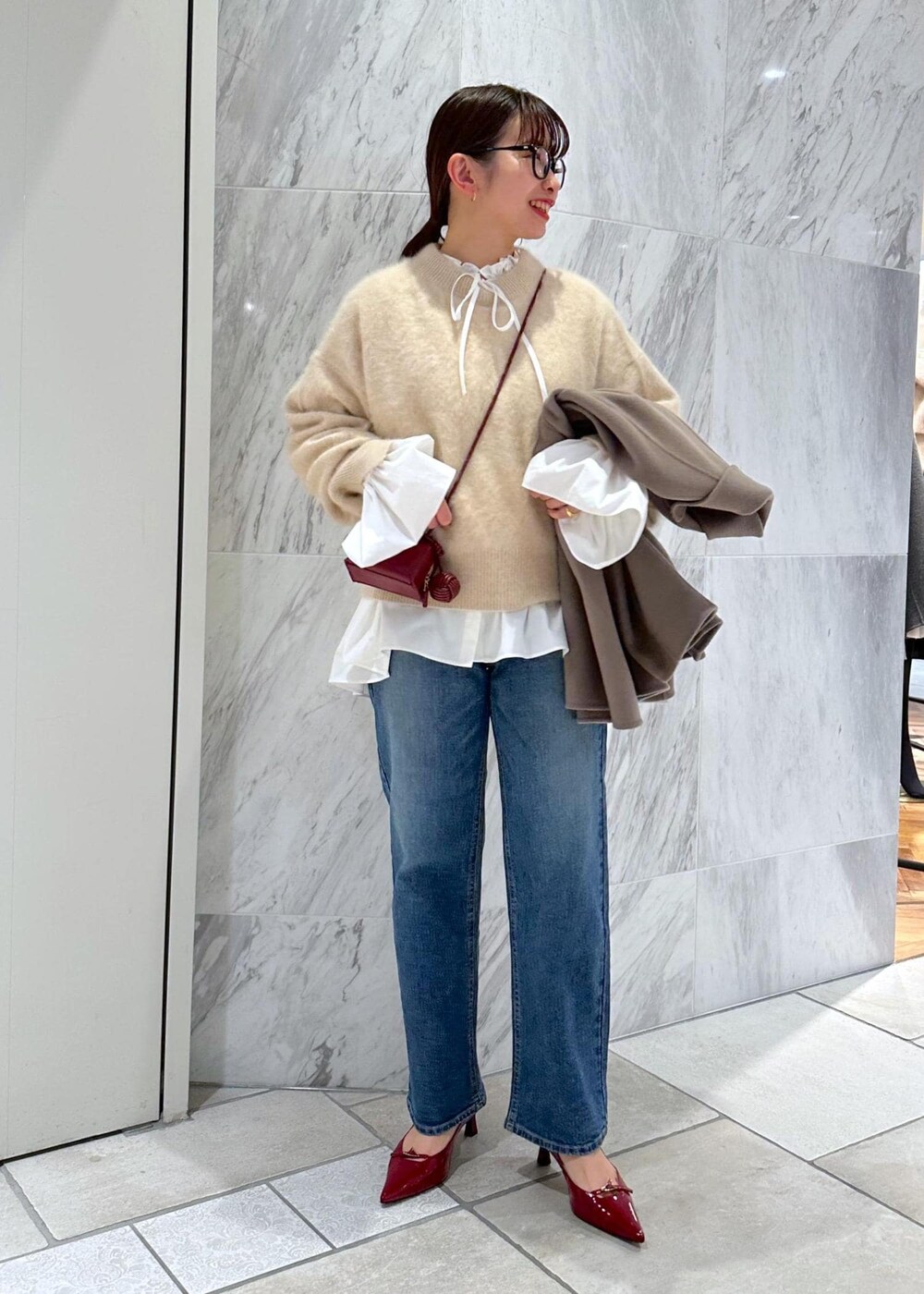 レッド系のパンプス、ベージュ系のニット/セーター、ベージュ系のピーコートを着用したレディースの冬コーディネートの10枚目の写真