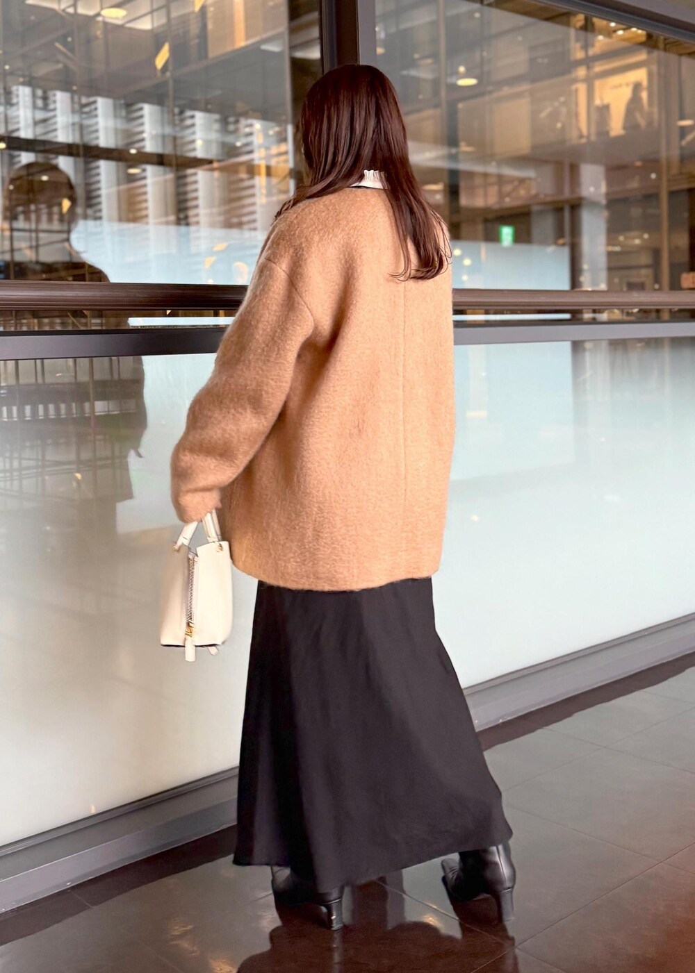 ホワイト系のハンドバッグ、ブラック系のスカート、ホワイト系のシャツ/ブラウスを着用したレディースの秋コーディネートの3枚目の写真