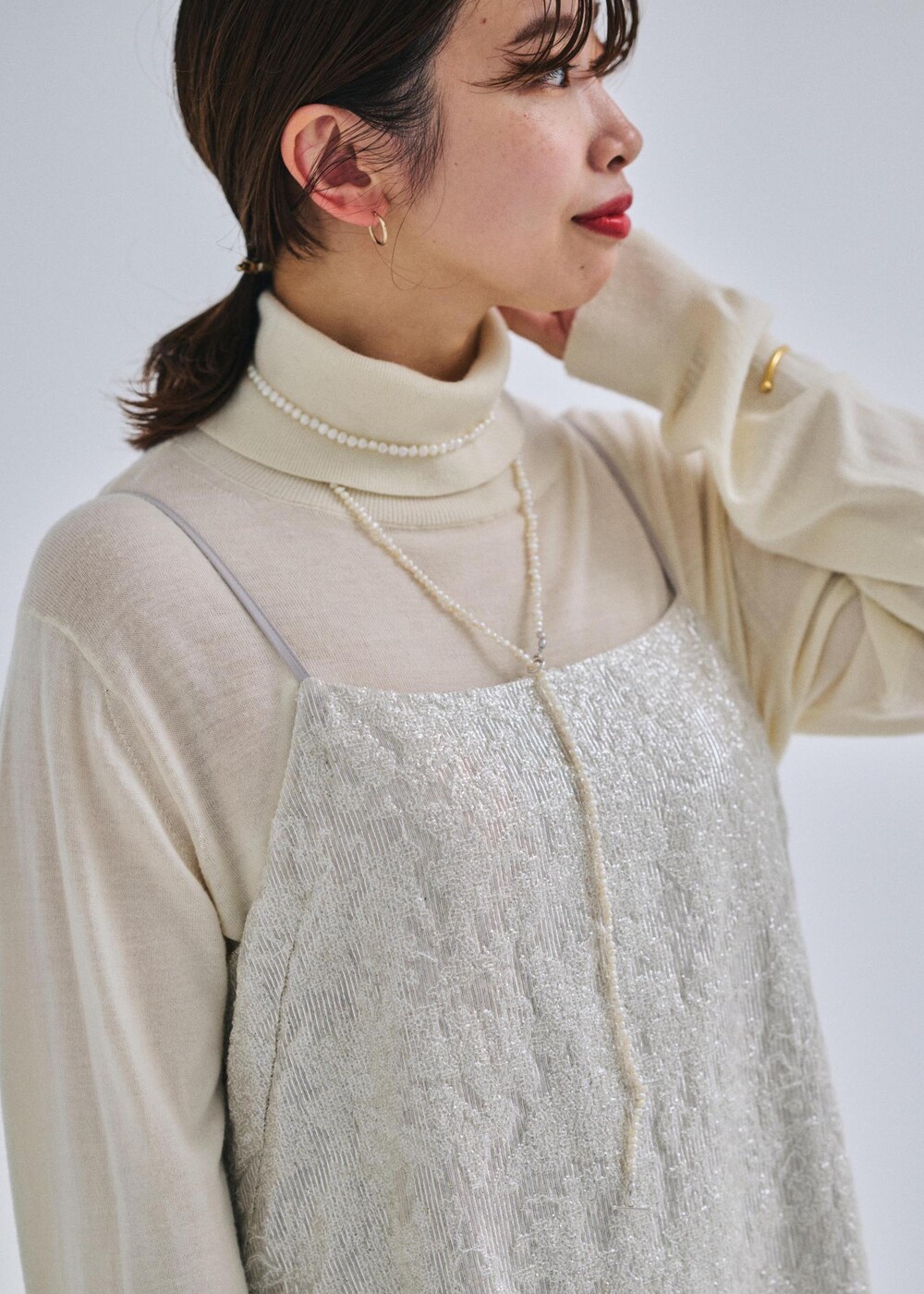 ベージュ系のショルダーバッグ、ブラック系のブーツ、ホワイト系のテーラードジャケットを着用したレディースの冬コーディネートの5枚目の写真