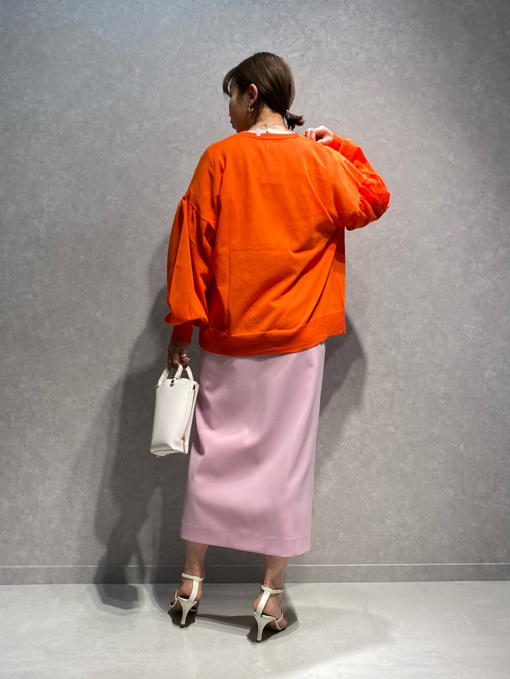 ホワイト系のショルダーバッグ、ホワイト系のサンダル、ピンク系のスカートを着用したレディースの春コーディネートの3枚目の写真