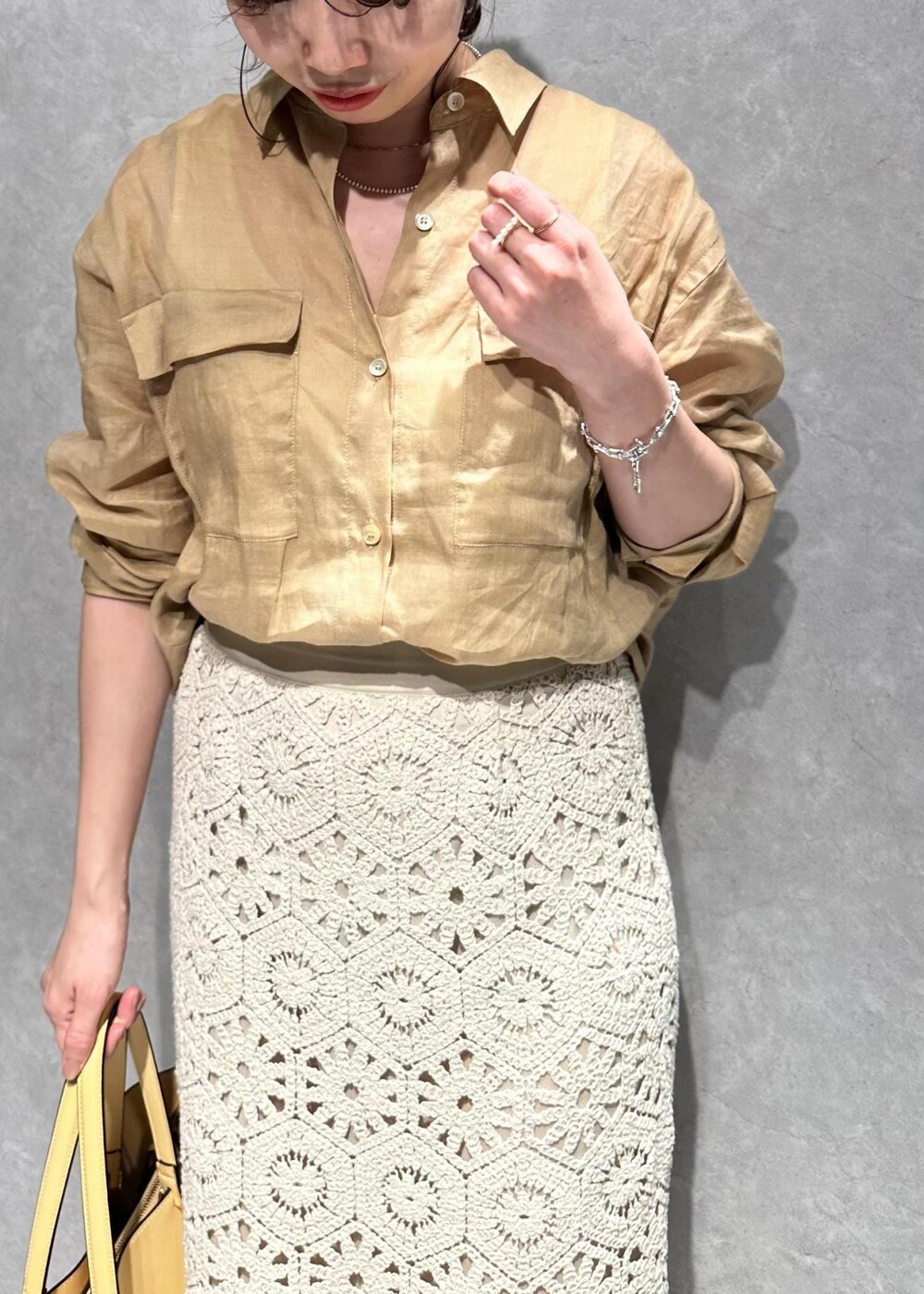ベージュ系のシャツ/ブラウス、ホワイト系のスカート、イエロー系のバッグを着用したレディースの春コーディネートの4枚目の写真