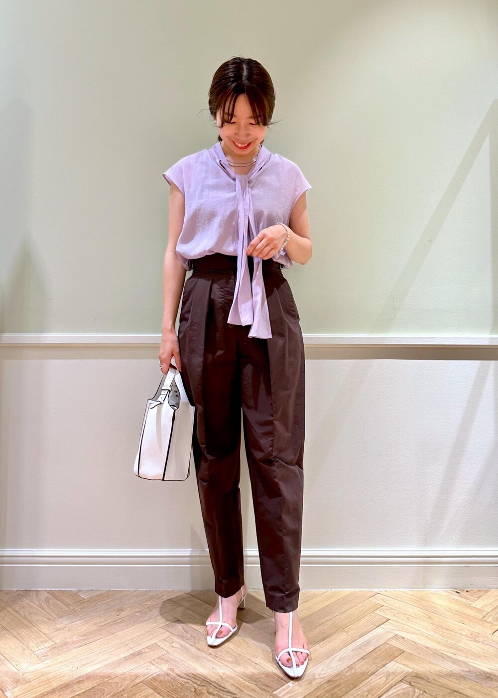 ホワイト系のハンドバッグ、パープル系のシャツ/ブラウス、ホワイト系のサンダルを着用したレディースの夏コーディネートの6枚目の写真