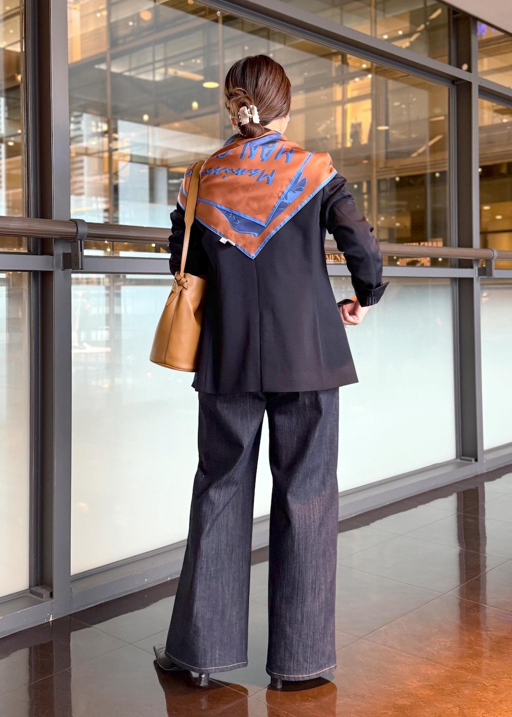 イエロー系のハンドバッグ、ブルー系のデニムパンツ、ホワイト系のカーディガン/ボレロを着用したレディースの秋コーディネートの3枚目の写真