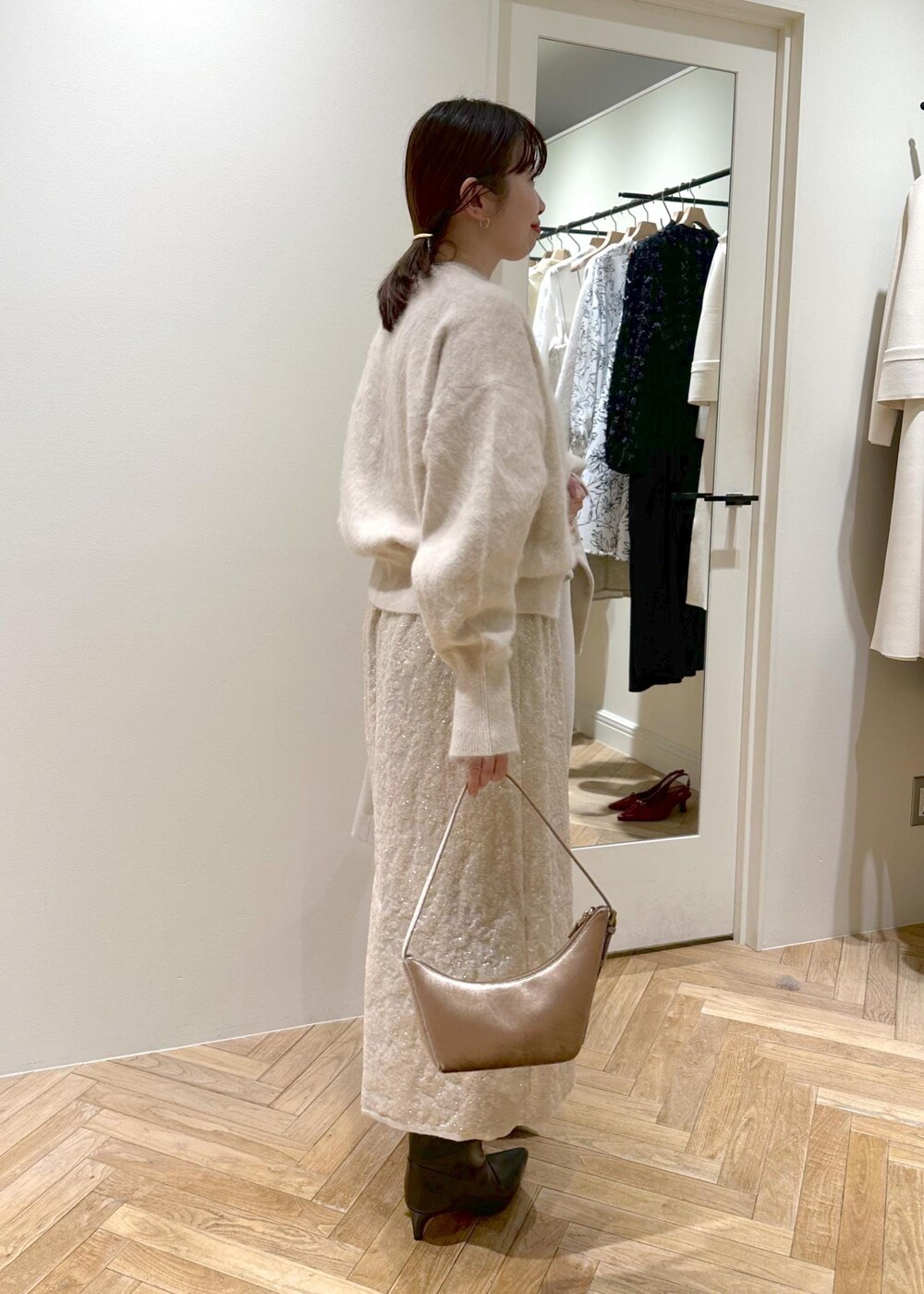 ブラック系のブーツ、ベージュ系のスカート、ベージュ系のニット/セーターを着用したレディースの冬コーディネートの3枚目の写真