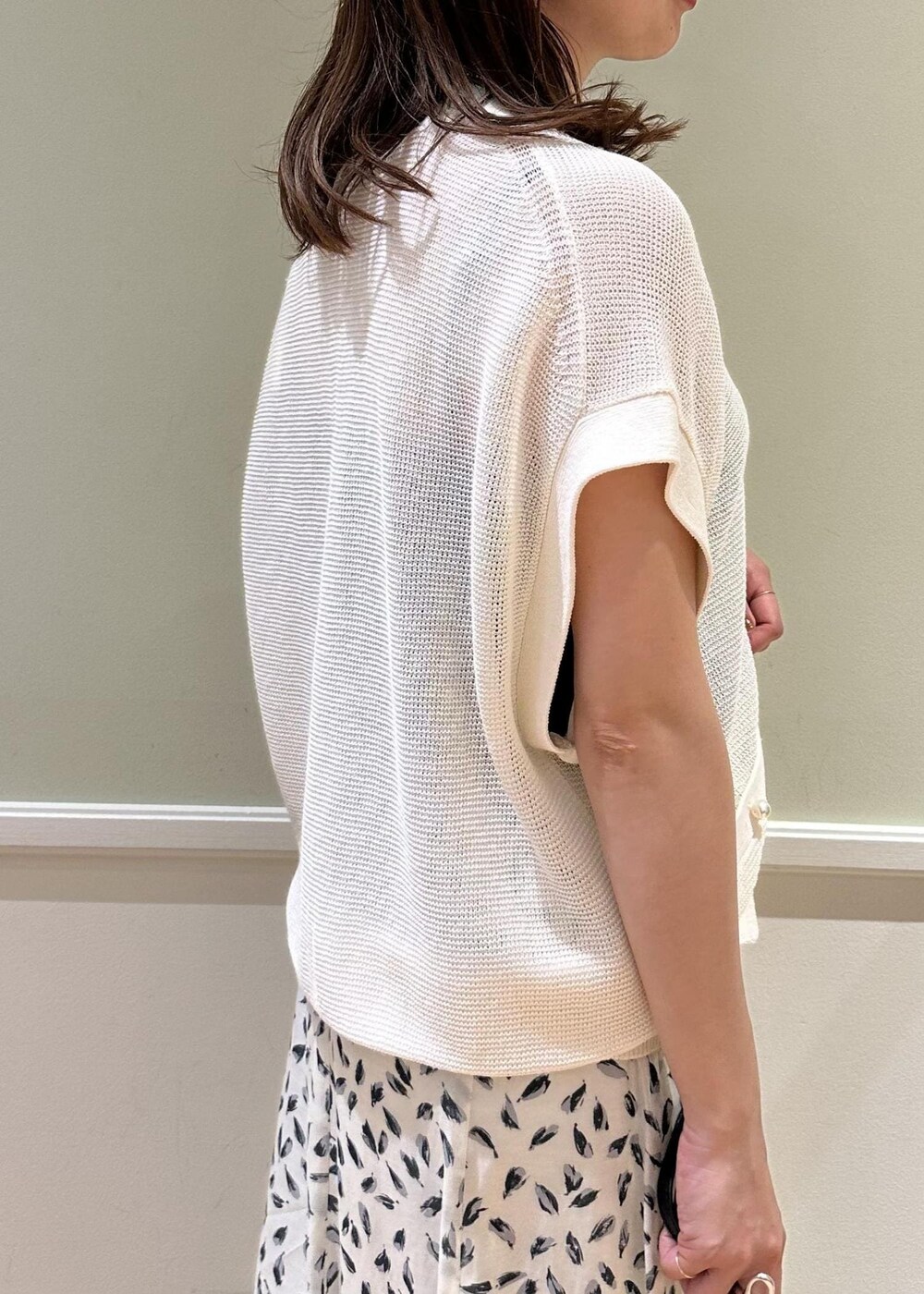 ブラック系のハンドバッグ、ホワイト系のスカート、ブラック系のサンダルを着用したレディースの夏コーディネートの6枚目の写真