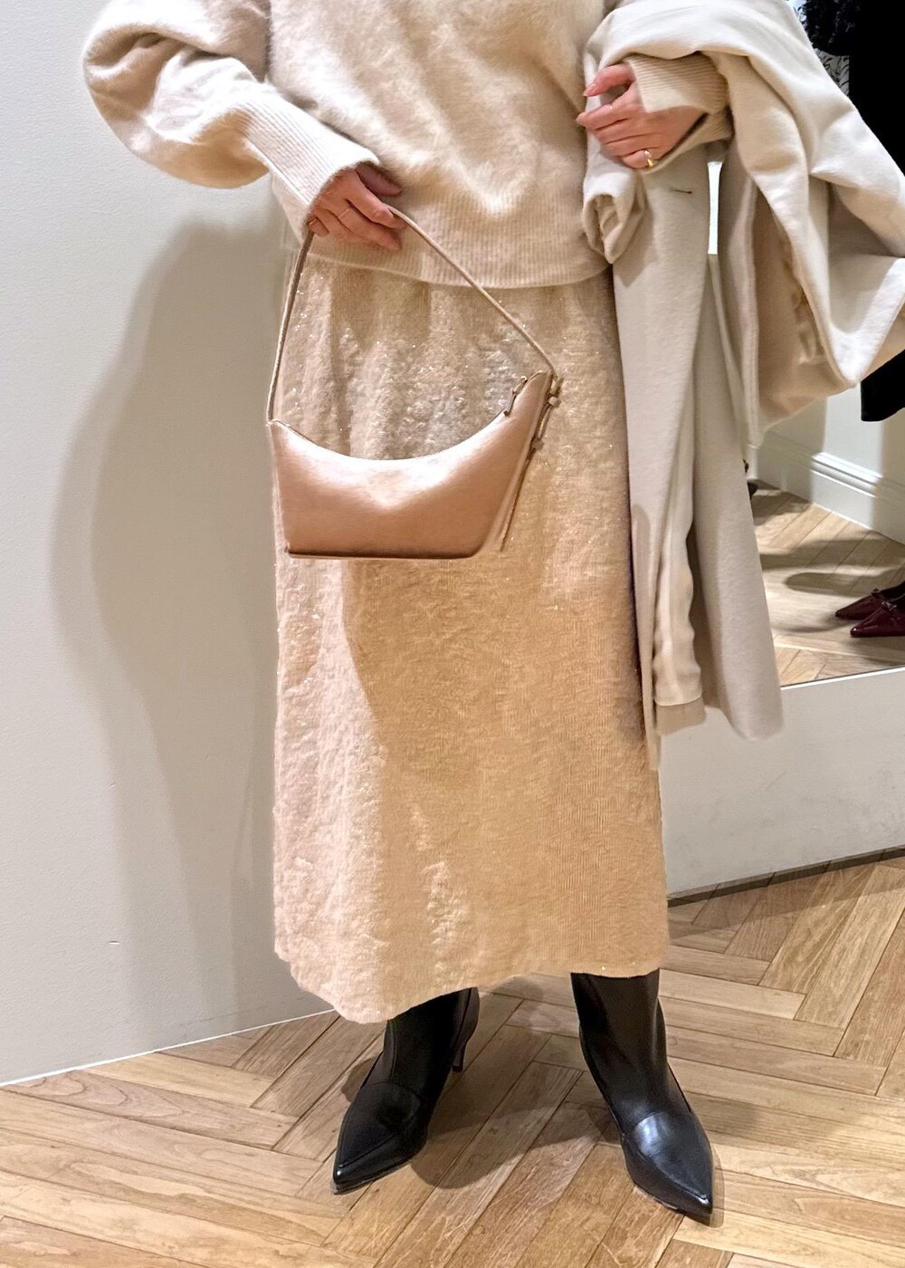 ブラック系のブーツ、ベージュ系のスカート、ベージュ系のニット/セーターを着用したレディースの冬コーディネートの9枚目の写真