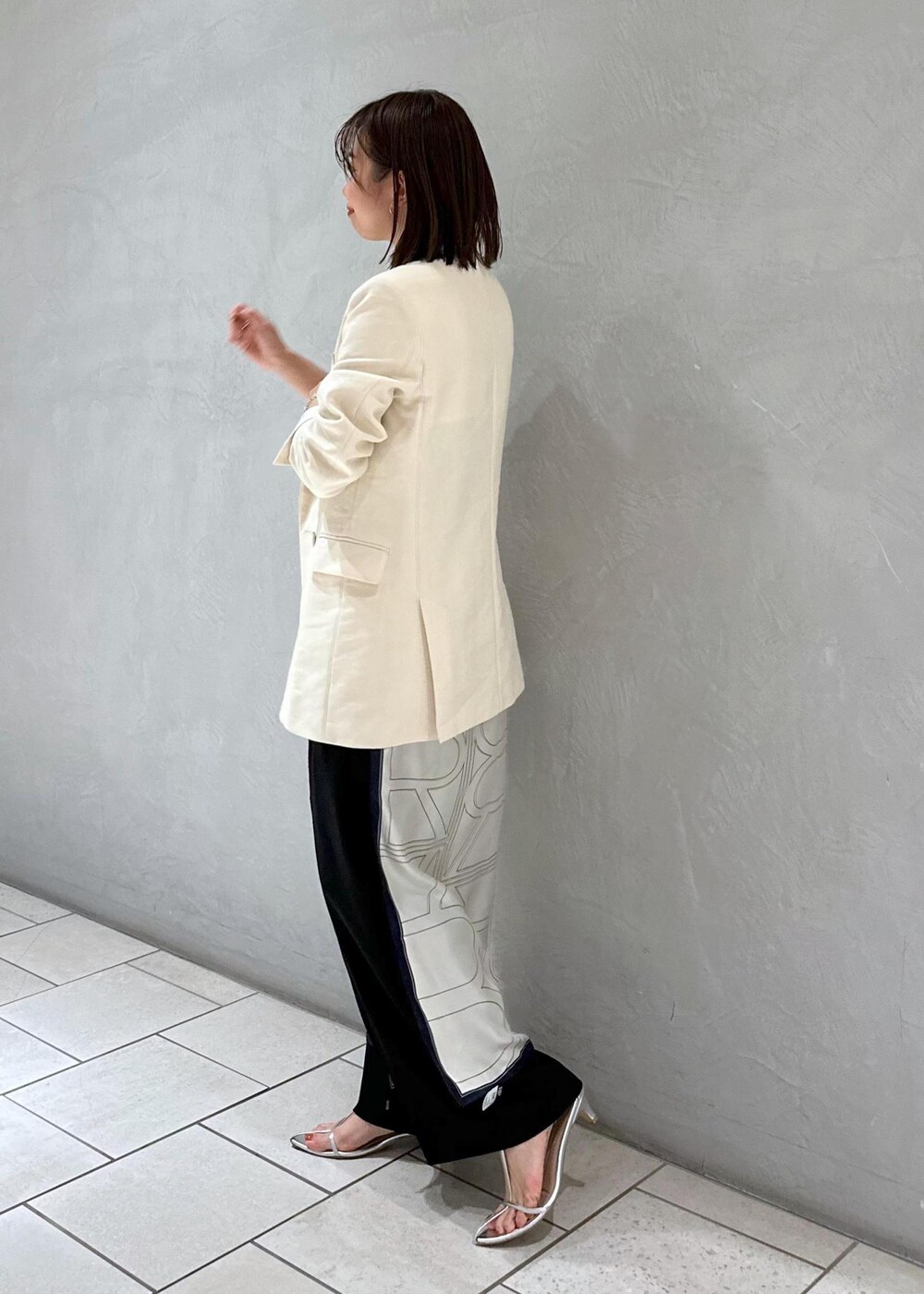 ブラック系のキャミソール、ホワイト系のテーラードジャケット、ホワイト系のバンダナ/スカーフを着用したレディースの冬コーディネートの3枚目の写真