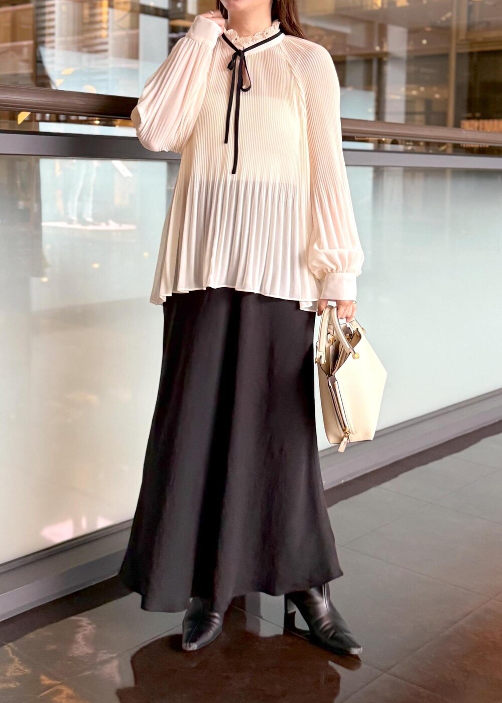 ホワイト系のハンドバッグ、ブラック系のスカート、ホワイト系のシャツ/ブラウスを着用したレディースの秋コーディネートの6枚目の写真