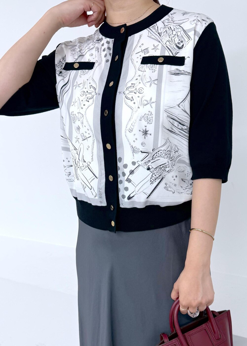 グレー系のスカート、ブラック系のシャツ/ブラウス、レッド系のショルダーバッグを着用したレディースの夏コーディネートの5枚目の写真