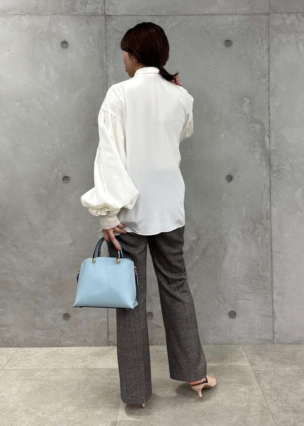 ブルー系のハンドバッグ、ベージュ系のパンプス、グレー系のその他パンツを着用したレディースの秋コーディネートの4枚目の写真