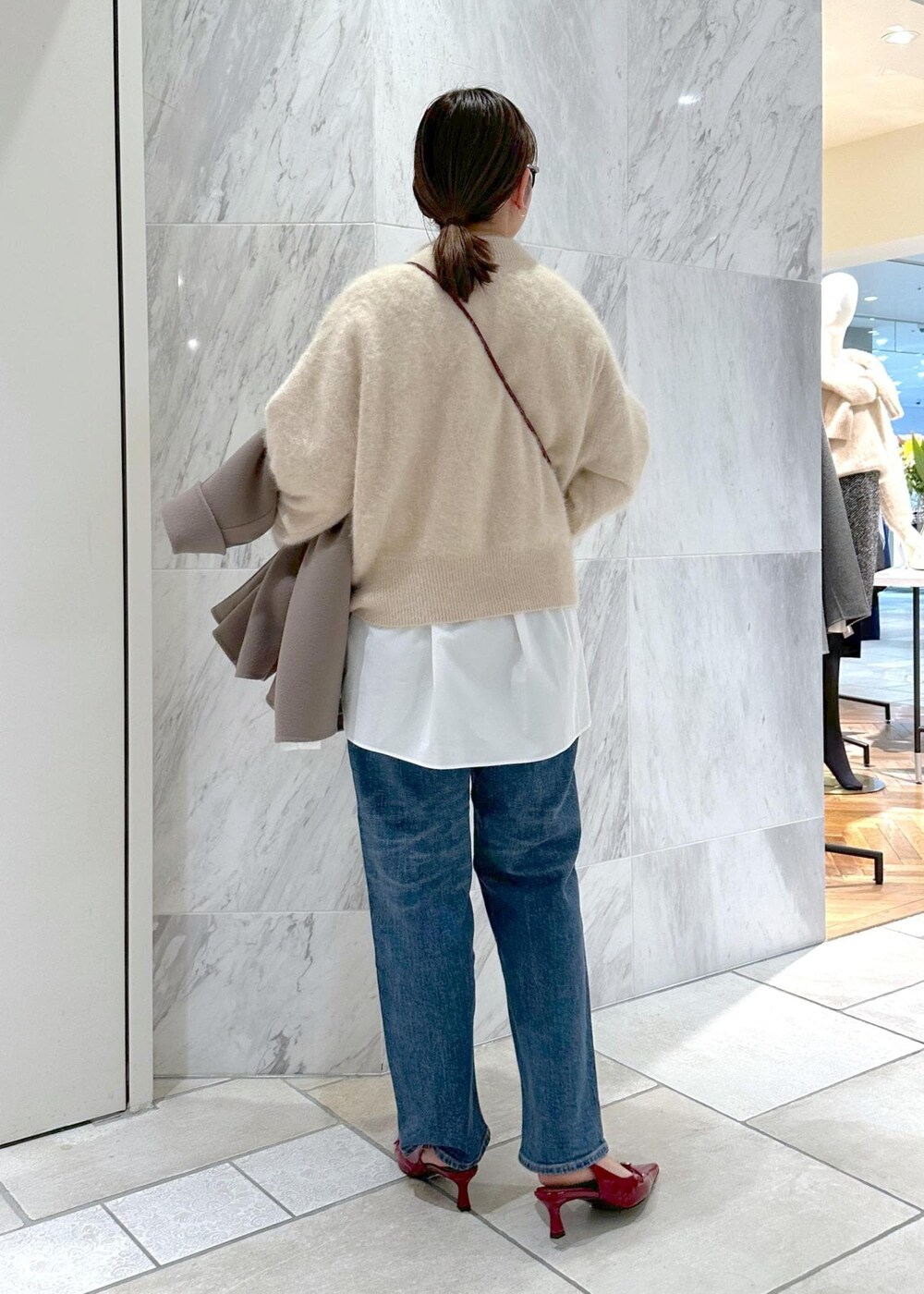 レッド系のパンプス、ベージュ系のニット/セーター、ベージュ系のピーコートを着用したレディースの冬コーディネートの4枚目の写真