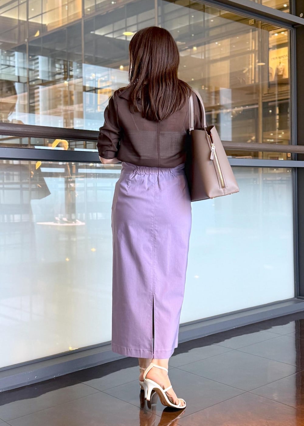 ブラウン系のトートバッグ、パープル系のスカート、ブラウン系のシャツ/ブラウスを着用したレディースの春コーディネートの3枚目の写真