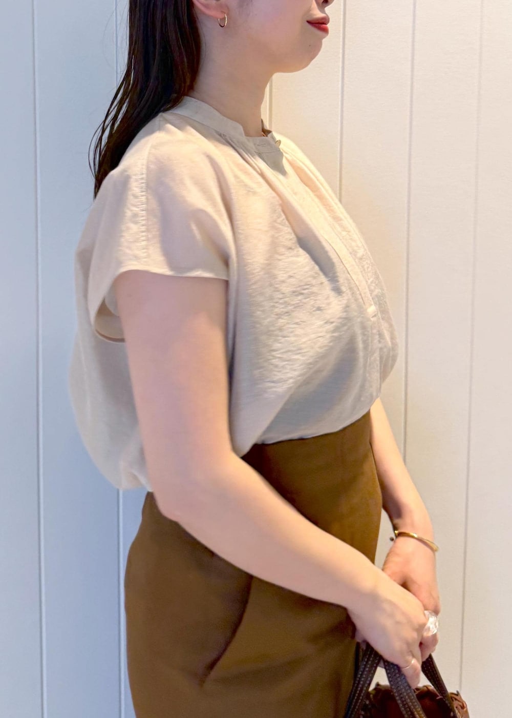 ブラウン系のスカート、ベージュ系のシャツ/ブラウスを着用したレディースの春コーディネートの6枚目の写真