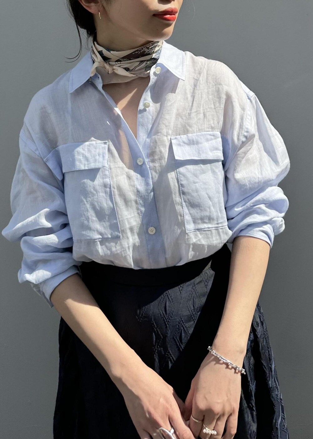 ブルー系のスカート、ブルー系のシャツ/ブラウス、ホワイト系のハンドバッグを着用したレディースの春コーディネートの5枚目の写真