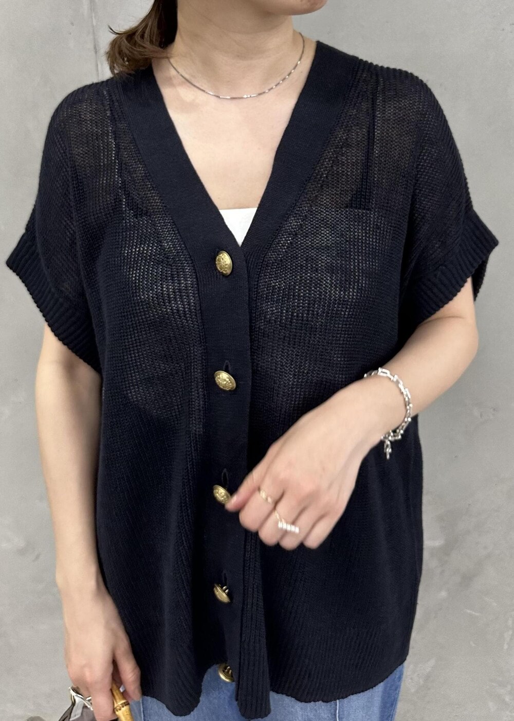 ブルー系のベスト、ブルー系のデニムパンツ、ホワイト系のサンダルを着用したレディースの春コーディネートの4枚目の写真