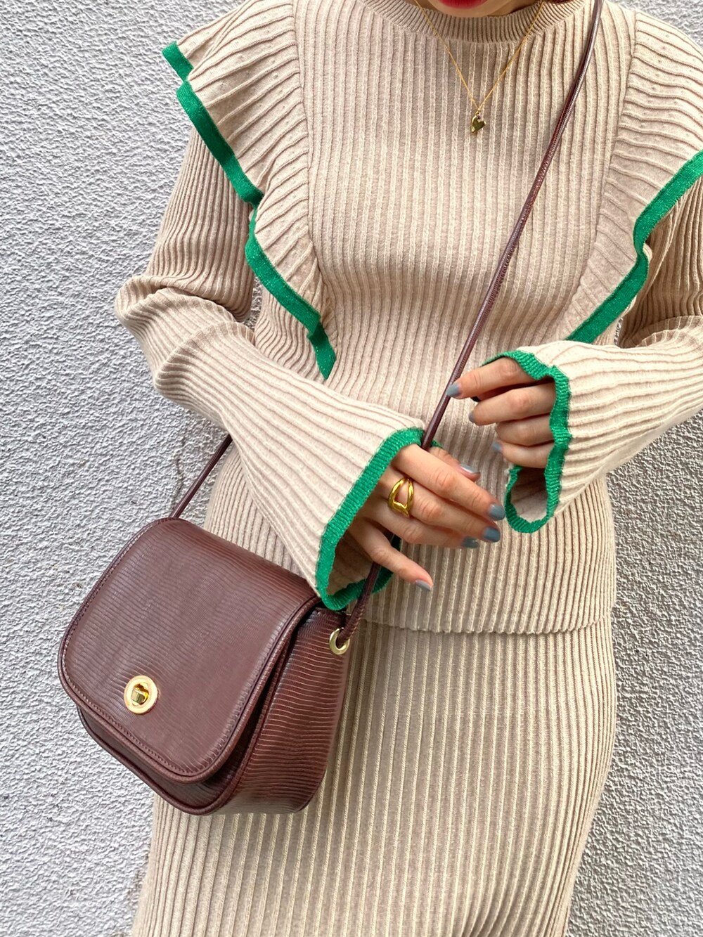 ベージュ系のニット/セーター、ベージュ系のスカート、ブラウン系のショルダーバッグを着用したレディースの冬コーディネートの4枚目の写真