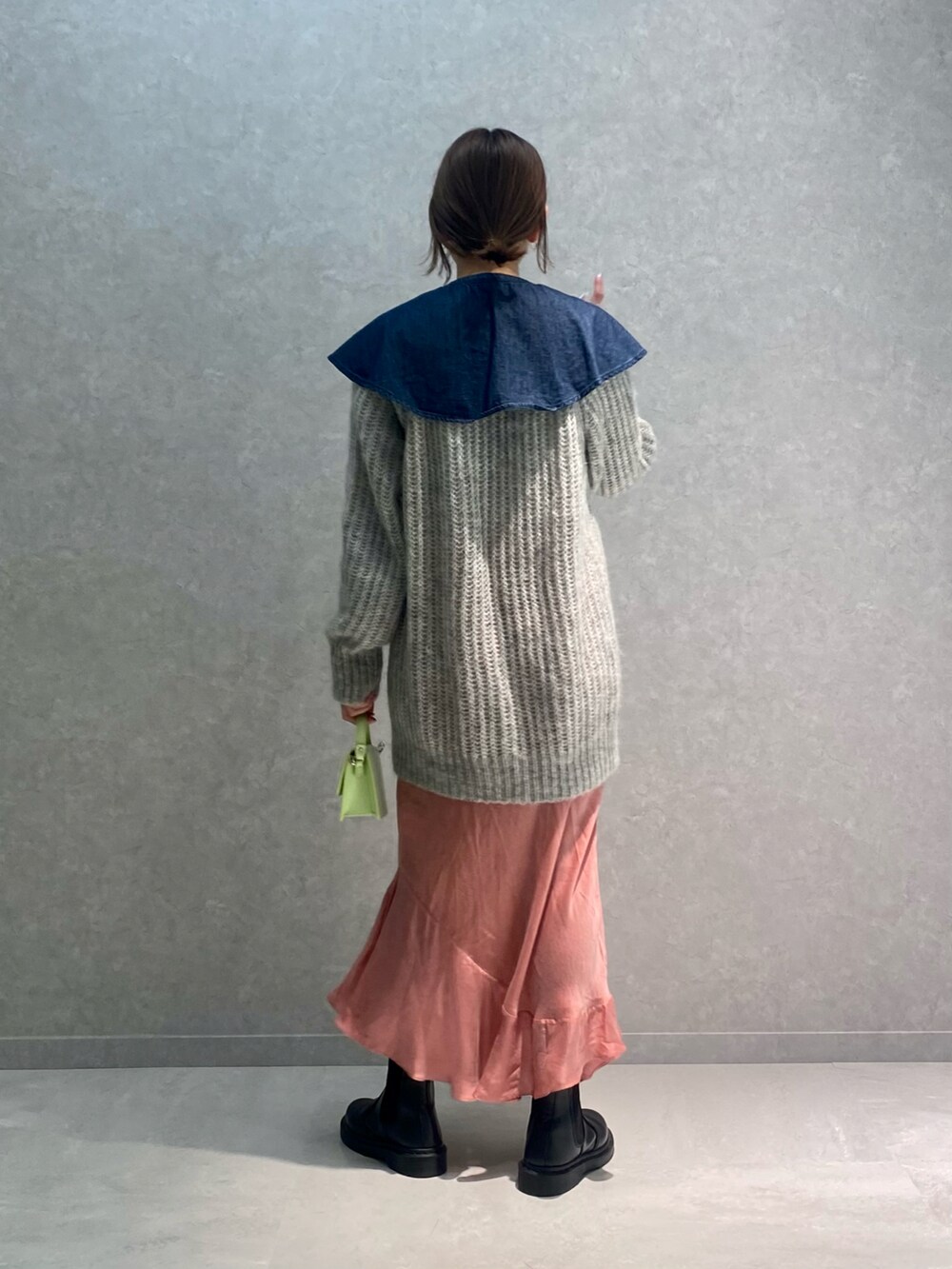 グレー系のニット/セーター、ブルー系のシャツ/ブラウス、グリーン系のバッグを着用したレディースの冬コーディネートの3枚目の写真