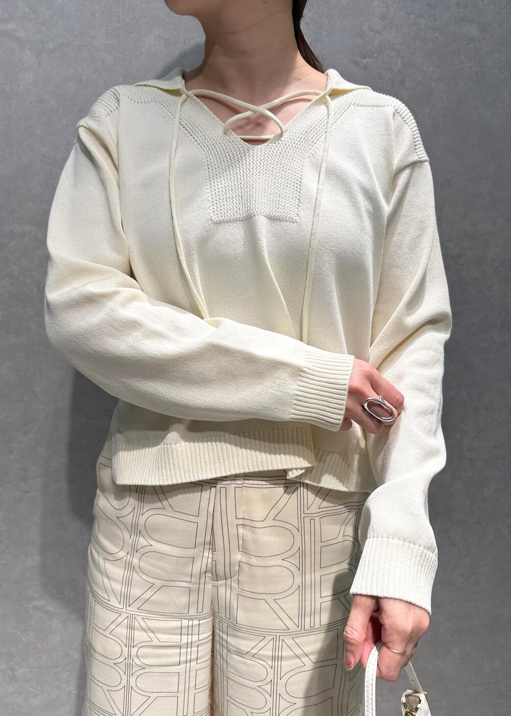 ホワイト系のニット/セーター、ホワイト系のその他パンツ、ホワイト系のハンドバッグを着用したレディースの春コーディネートの8枚目の写真