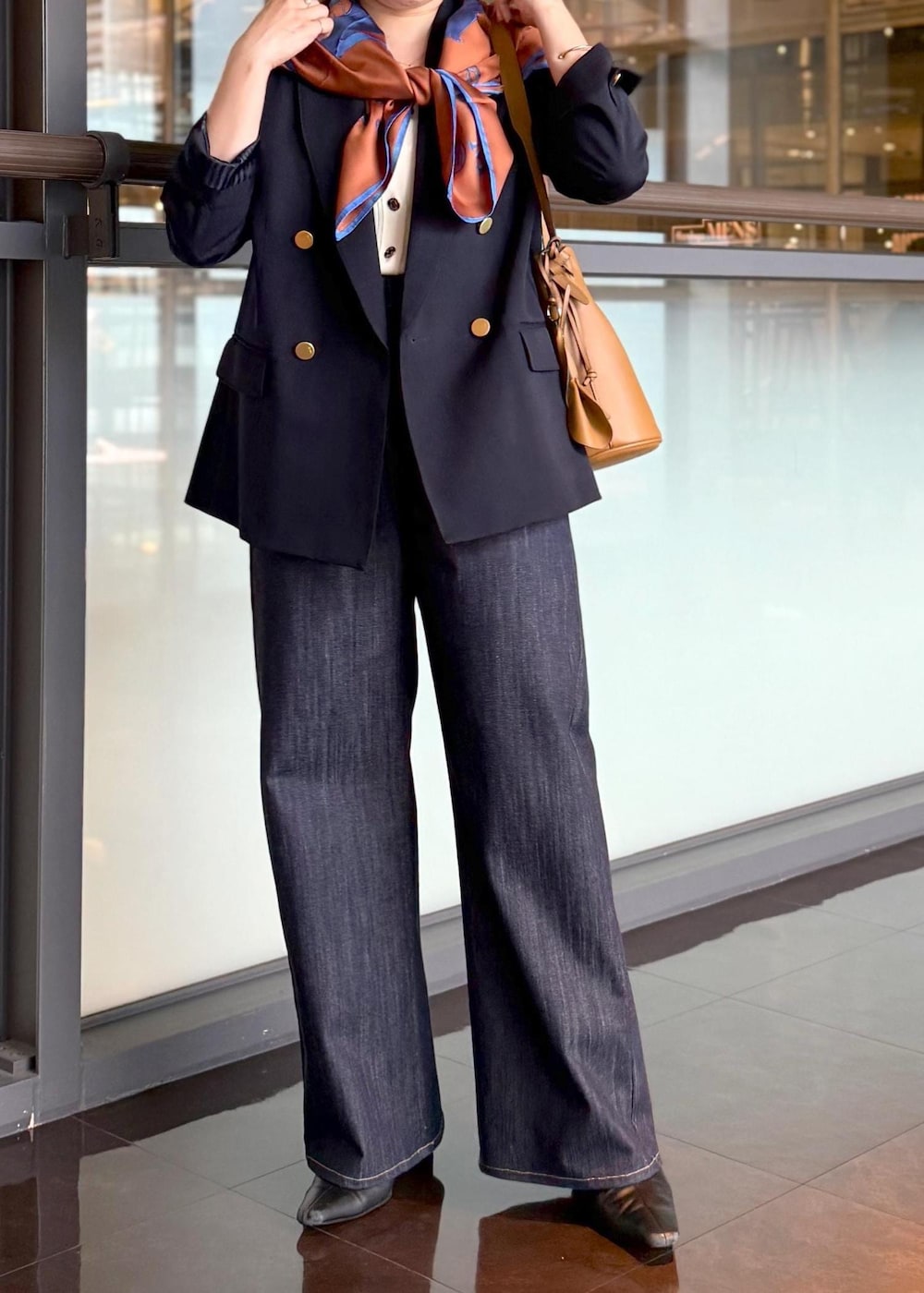 イエロー系のハンドバッグ、ブルー系のデニムパンツ、ホワイト系のカーディガン/ボレロを着用したレディースの秋コーディネートの7枚目の写真