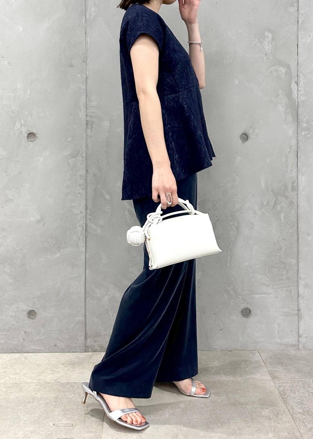 ブルー系のその他パンツ、シルバー系のサンダル、ホワイト系のショルダーバッグを着用したレディースの春コーディネートの3枚目の写真