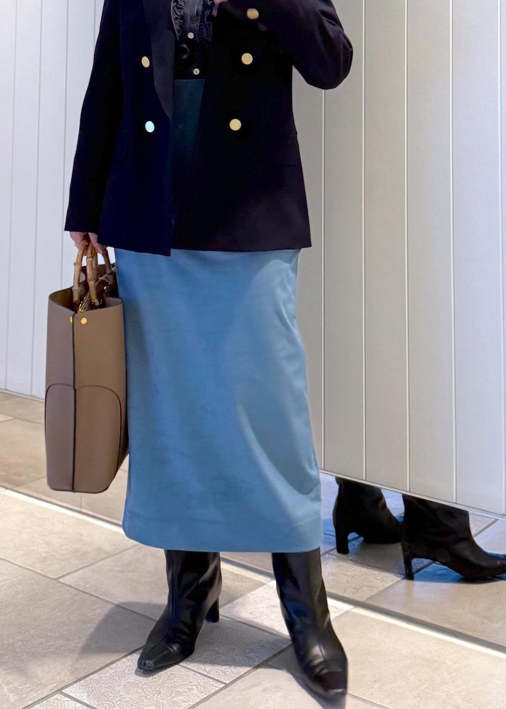 ベージュ系のトートバッグ、ブルー系のスカート、ブルー系のテーラードジャケットを着用したレディースの秋コーディネートの9枚目の写真