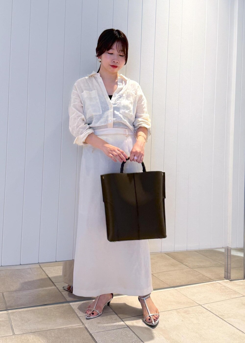 ホワイト系のスカート、グリーン系のトートバッグ、ホワイト系のシャツ/ブラウスを着用したレディースの夏コーディネートの2枚目の写真