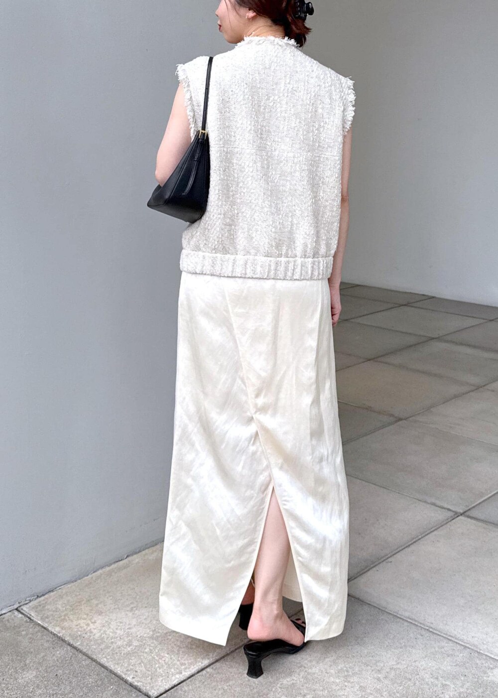ホワイト系のスカート、ホワイト系のベストを着用したレディースの夏コーディネートの9枚目の写真