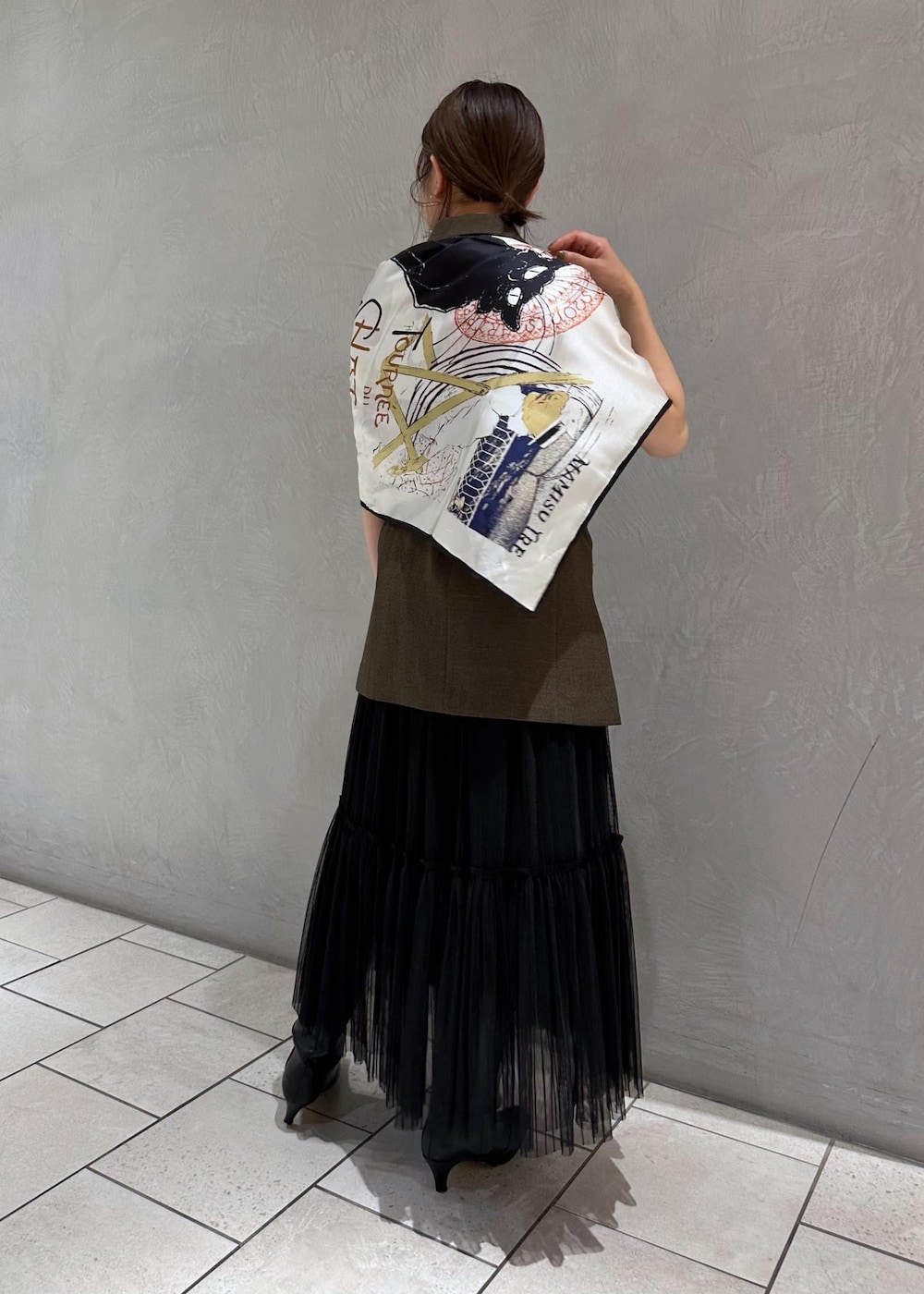 ブラック系のスカート、ゴールド系のブローチ/コサージュ、ブラック系のバンダナ/スカーフを着用したレディースの夏コーディネートの3枚目の写真