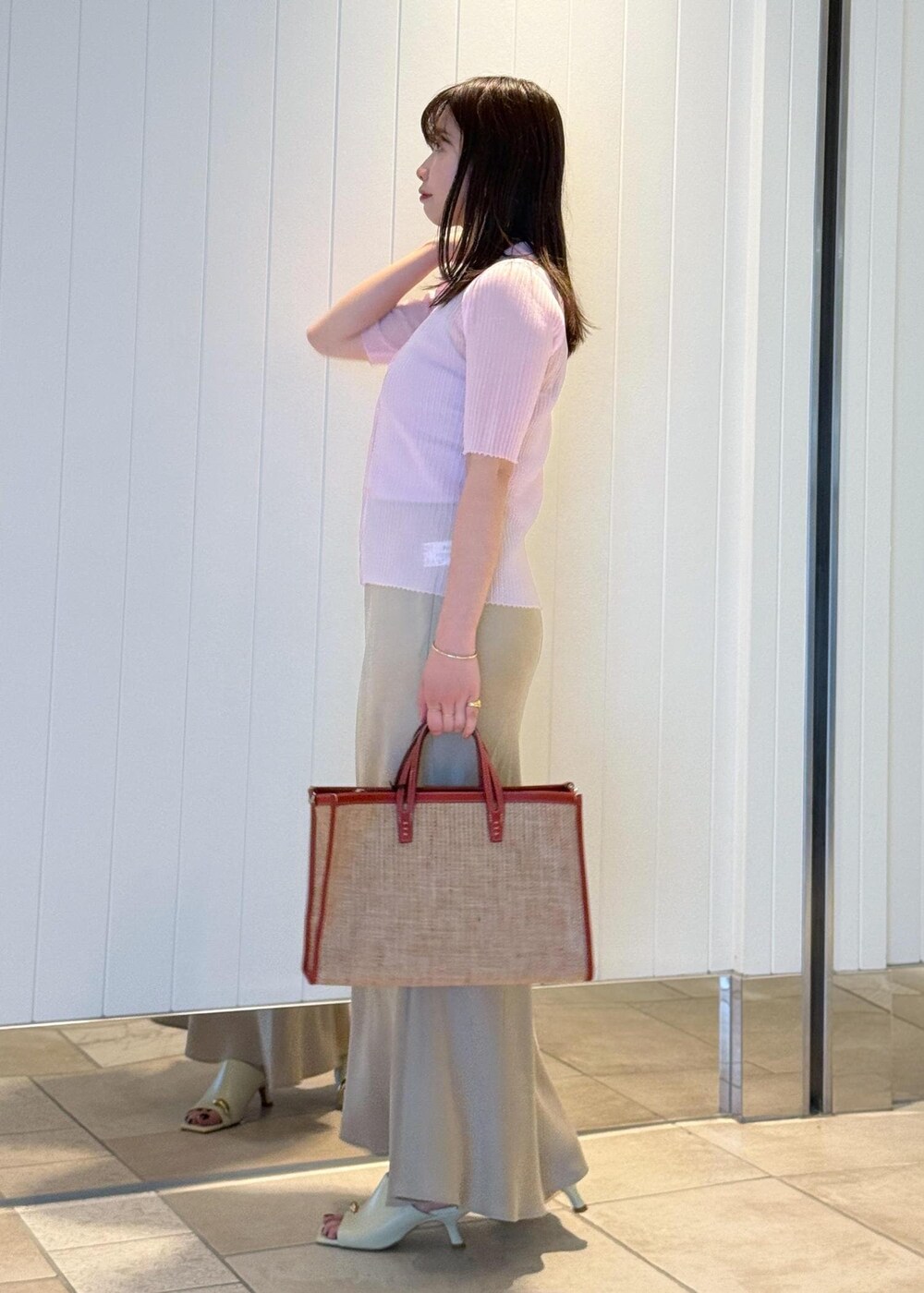 ベージュ系のサンダル、ベージュ系のスカート、ピンク系のキャミソールを着用したレディースの春コーディネートの3枚目の写真