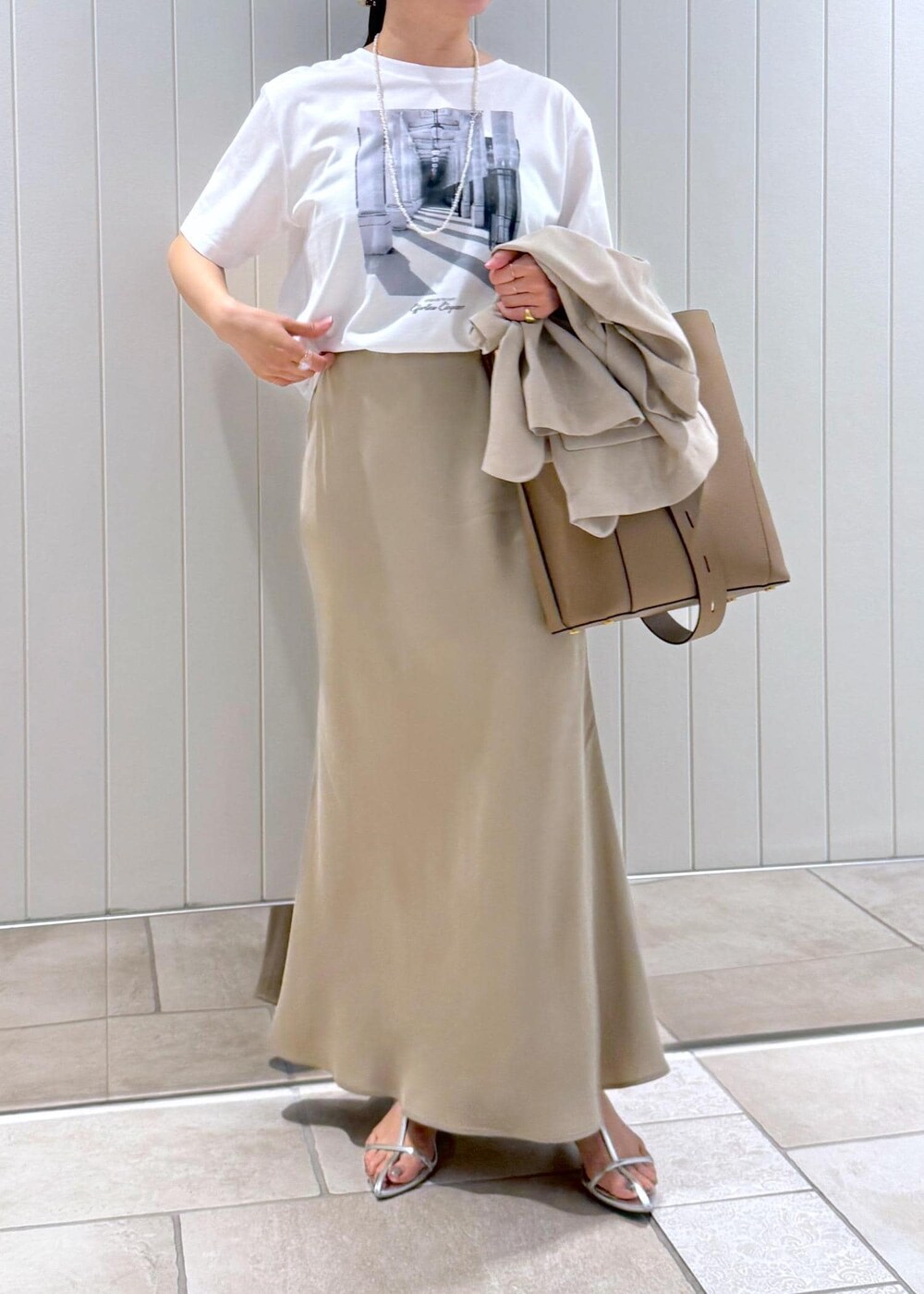 ベージュ系のトートバッグ、ホワイト系のTシャツ/カットソー、ベージュ系のスカートを着用したレディースの春コーディネートの7枚目の写真