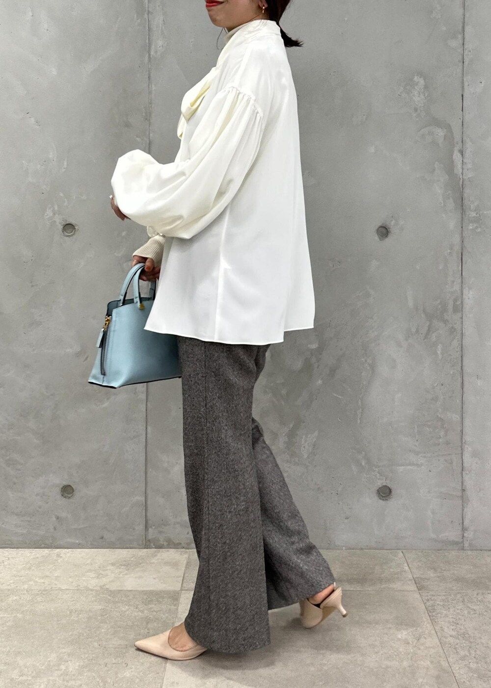 ブルー系のハンドバッグ、ベージュ系のパンプス、グレー系のその他パンツを着用したレディースの秋コーディネートの7枚目の写真